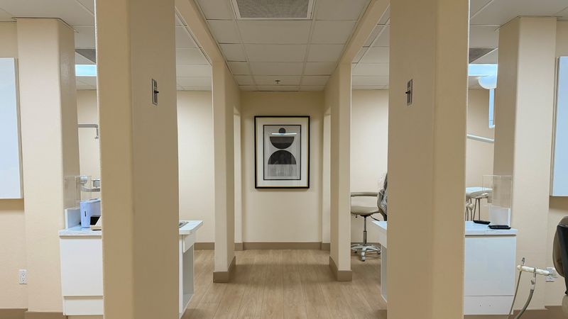 The corridor inside the practice, with a treatment room on either side.